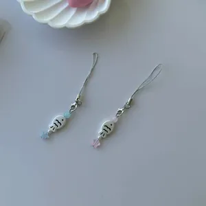 Set of two cute phone charms with cartoon beads and colorful stars on a white background