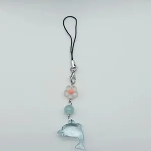 Detail eines süßen blauen Delfin-Anhängers mit Blumenperlen an einem Schlüsselband