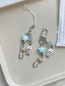 Close-up of handmade phone charm with blue beads, silver fish, and heart pin charms