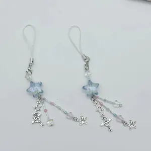 Detail of two star phone charms with blue acrylic stars and silver wing key pendants