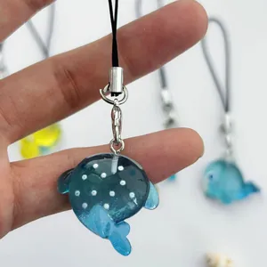 Dettaglio di un ciondolo a forma di squalo balena blu con pois bianchi e gancio in metallo