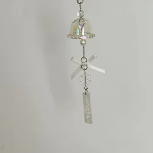 Detail of snowflake charm with ribbon bow and iridescent glass bell pendant