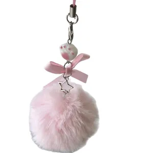 Pink plush ball keychain with a silk bow, ceramic cat paw bead, and silver star charm