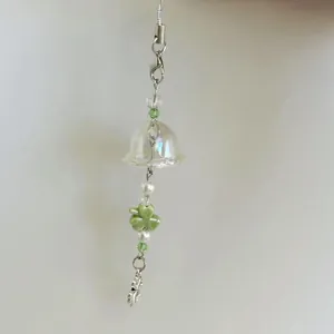 Handmade silver chain phone charm with green four-leaf clover and clear bell pendant