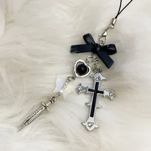 Y2K butterfly cross syringe phone charm with black ribbon bow on white plush background