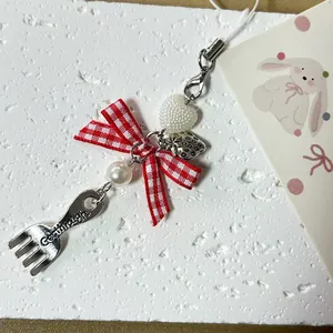 Pastoral bow phone strap with red plaid ribbon, metal strawberry, and heart bead charms