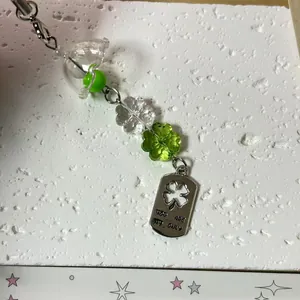 Handmade clover beaded phone charm with bell beads and engraved metal lucky tag
