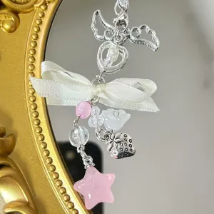 Pink star and ribbon beaded phone charm with silver strawberry pendant on mirror background