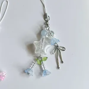 Detail van de kralen sterhanger met zilveren strik en blauwe lelietje-van-dalen