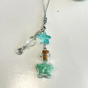 Detalle de correa de cuentas con perla de estrella azul y colgante de botella de vidrio