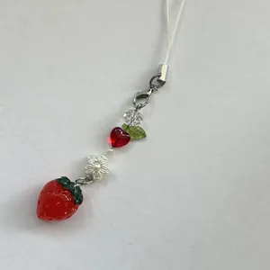 Bijou de téléphone fraise fait main avec cœur rouge et perles de fleurs blanches
