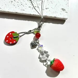Cute strawberry phone charm strap featuring red charms and clear star beads on white background