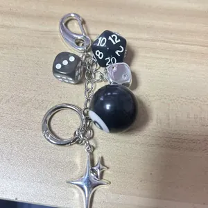 Detail of retro dice keychain with stars and dark green mixed beads hanging on wood