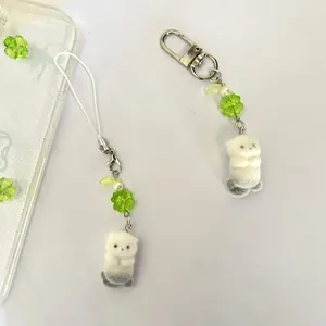 Close-up of cute sea otter plush charms with green clover beads and white pearls