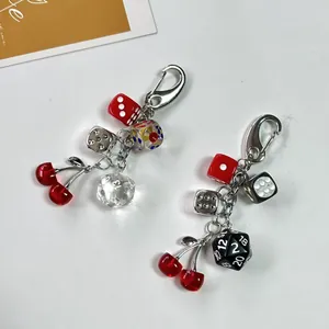 Creative cherry and multi-colored dice keychain with silver metal clasp on white background