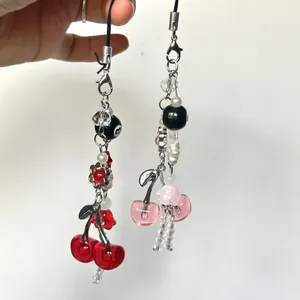 Sweet cherry and jellyfish beaded phone charms with red and pink accents on white background