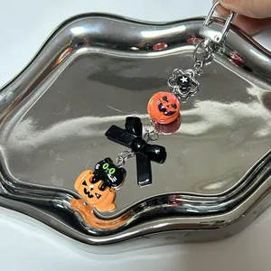 Halloween phone charm featuring a black cat in pumpkin pendant and orange beads