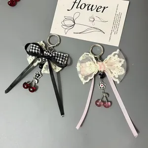 Pendentif cerise avec nœud en dentelle pour sacs et téléphones en motif noir et rose