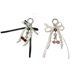 Elegant beaded pearl ribbon bow keychains with cherry pendants in black and pink