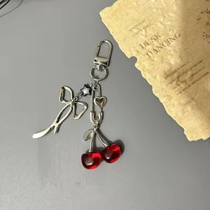 Sweet cherry charm with silver bow and star pendant on a stylish metal phone chain