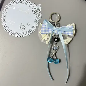 Pendentif cerise à nœud en dentelle bleue avec ruban à carreaux et anneau argent