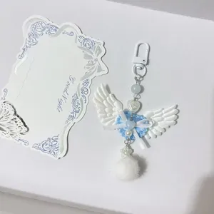 Porte-clés ailes d'ange Y2K avec cœur en dentelle bleue et pompon blanc doux
