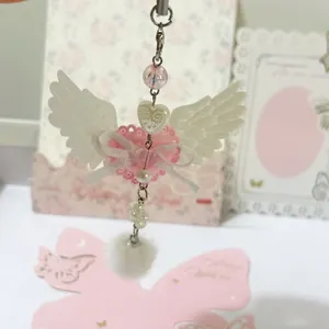 Pink heart keychain with angel wings and plush pompom for bags or phone cases