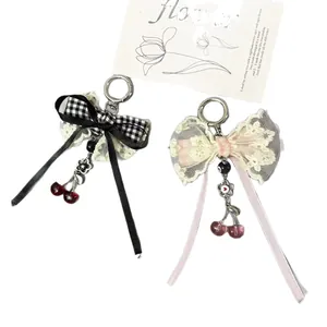 Porte-clés nœud à carreaux avec dentelle et breloques cerise en rose et noir chic
