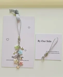 Close-up of star-themed phone charm with colorful macaron beads and silver star pendants