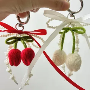 Llavero de tulipán hecho a mano con flores rojas y crema y decoración de lazo de cinta