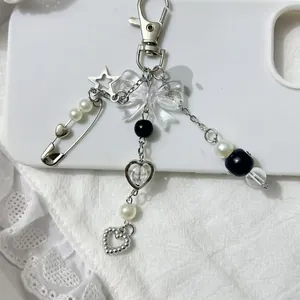 Détail macro du pendentif étoile argentée et nœud en acrylique sur un porte-clés