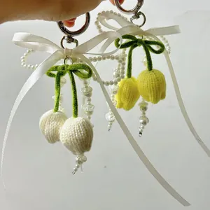 Llavero de flor tejida a mano con lazo de cinta blanca y adornos de perlas