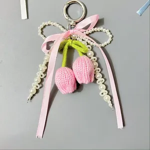 Detalle de colgante de tulipán rosa hecho a mano con perlas y lazo para bolsos y llaves