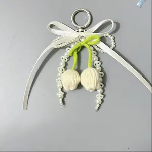 Detalle del colgante de tulipán tejido con lazo de seda y perlas para bolsos y llaves