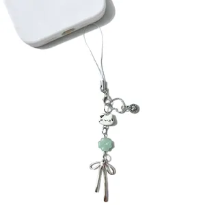 Bijou de téléphone chat avec tête de chaton en céramique et trèfle sur fond blanc