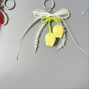 Detalle de colgantes de tulipanes amarillos hechos a mano con cintas y perlas