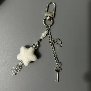 Bijou de téléphone perlé fait main avec étoile en peluche et aile d'ange argentée