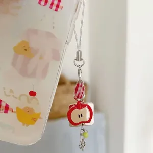 Handmade beaded phone charm with red apple, plaid fabric, and clover on clear case
