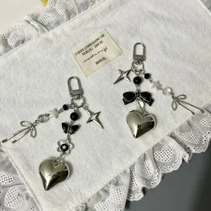 Y2K silver heart and butterfly charm keychains with black bows and metal stars