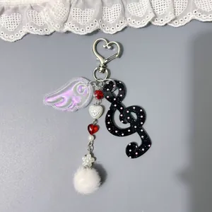 Porte-clés mignon de style coréen avec aile en acrylique et note de musique sur gris