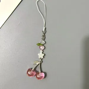 Close-up of a sweet beaded strawberry phone charm with pink heart and white floral beads