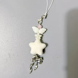 Detalle de llavero de cuentas hecho a mano con estrella de felpa y colgante de lazo