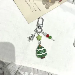 Détail d'un porte-clés sapin de Noël en résine verte avec étoile et perles