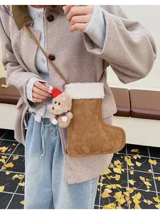 Détail du sac botte de Noël en daim marron avec petit ours en peluche et bord blanc