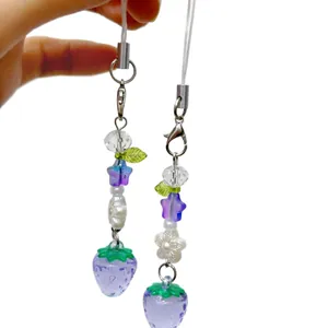 Cute purple strawberry beaded phone charm with star beads and silver lobster clasp on white background