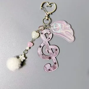 Porte-clés clé de sol violet avec ailes roses scintillantes et pompon blanc en peluche