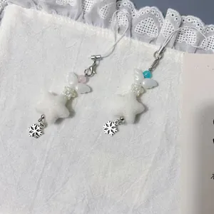 Colgante estrella Y2K hecho a mano con alas de felpa y perlas sobre encaje blanco