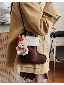 Détail du sac bandoulière botte de Noël avec breloque ours et bordure en polaire blanche