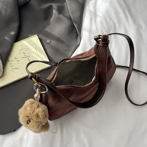 Vintage dark brown crescent shoulder bag in suede texture with cute plush bear pendant