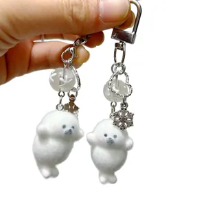 Cute white plush seal keychains with silver snowflake and heart charms for bags